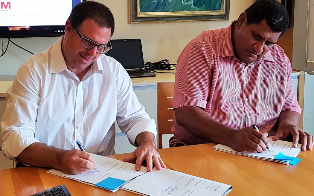 James Ashworth from Velocity Brand Management and FRU CEO John O'Connor sign the agreement.