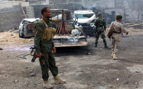 Yemeni loyalist forces gather at the scene of a suicide attack targeting the police chief in the base of the Saudi-backed government on April 28.