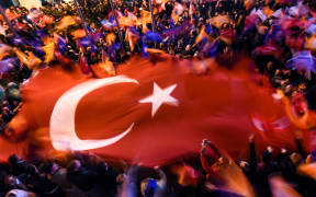 Supporters of Turkey's Justice and Development Party (AKP) in Istanbul wave a giant Turkish flag as they celebrate the election result.