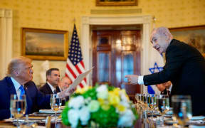 Israeli Prime Minister Benjamin Netanyahu, right, hands a letter he sent to the Nobel Peace Prize committee to nominate US President Donald Trump, left, for the Nobel Peace Prize, during a dinner in the Blue Room of the White House on 7 July 2025 in Washington, DC.