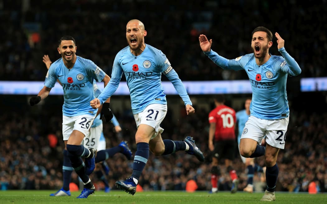 David Silva of Manchester City celebrates with teammates Riyad Mahrez and Bernardo Silva.