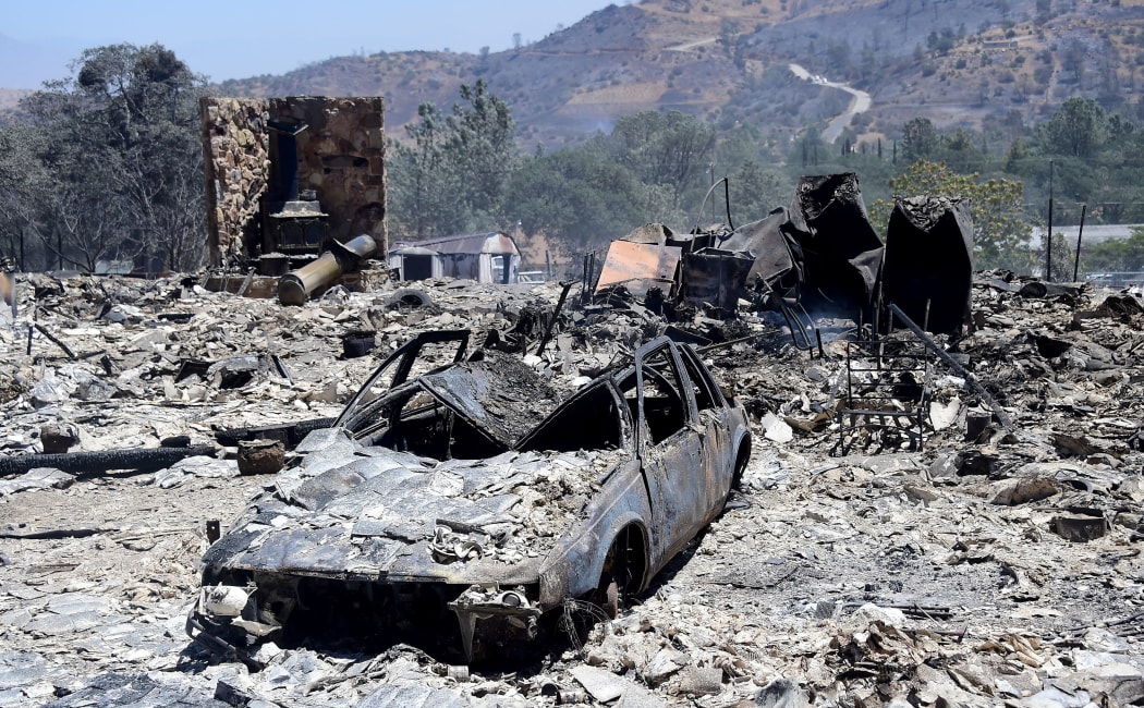 Rubble from a demolished home with vehicle out front are seen in the community of Squirrel Valley in Lake Isabella, California on June 24, 2016.