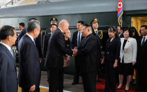 North Korea's leader Kim Jong Un (centre R) and his daughter Kim Ju Ae (3rd R) being greeted by Chinese officials upon their arrival at the Beijing Railway Station.