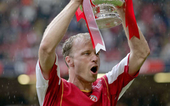 Arsenal striker Dennis Bergkamp celebrates with the trophy after their penalty shoot-out victory over Man Utd in the FA Cup Final. 2005.