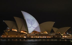 A Hanukkah menorah is projected onto the sails of the Sydney Opera House in memory of the victims of a shooting at Bondi Beach, in Sydney on 15 December, 2025.