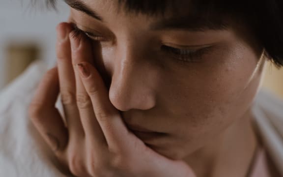 woman with hand on face