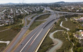 Snaking on and off ramps of the North Western Motorways empty of traffic looking back to the city.