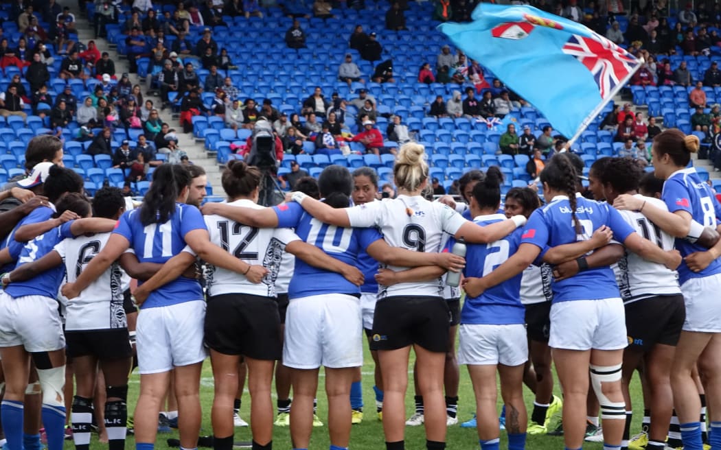 The Samoa and Fiji women's sevens team huddle together following the Oceania Championships final.