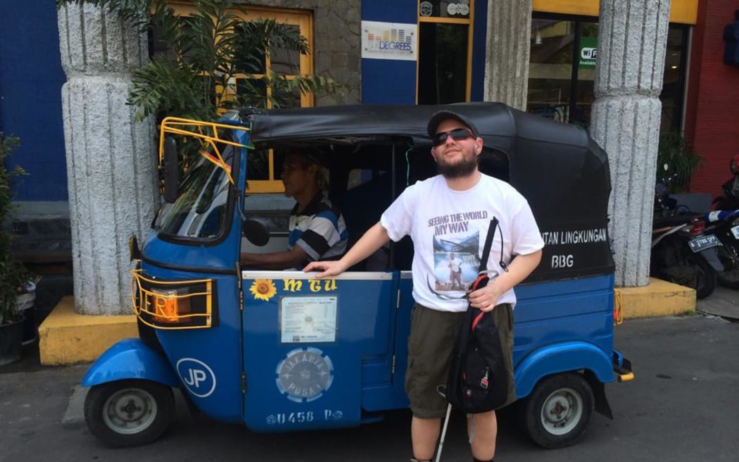 Tony Giles in Jakarta standing in front of a bajaj