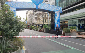 Armed police stand behind a cordon on Auckland's Queen Street following a serious shooting incident in the CBD on 20 July, 2023.