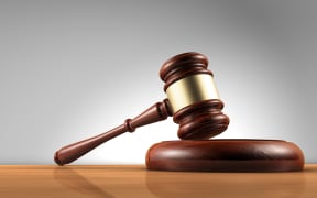 Judge, law, lawyer and Justice concept with a 3d render of a gavel on a wooden desktop with grey background.