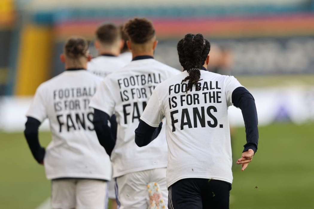 Leeds United players wear T-shirts with slogans against a proposed new European Super League during the warm up for the English Premier League football match between Leeds United and Liverpool