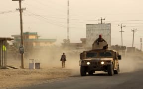 Afghan security forces - who have been engaged in ongoing fighting with Taliban fighters - travel in a Humvee in Kunduz on 28 September 2015.
