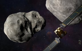 This artist's illustration obtained from NASA on November 4, 2021 shows the DART spacecraft and the Italian Space Agency’s (ASI) LICIACube prior to impact at the Didymos binary system.