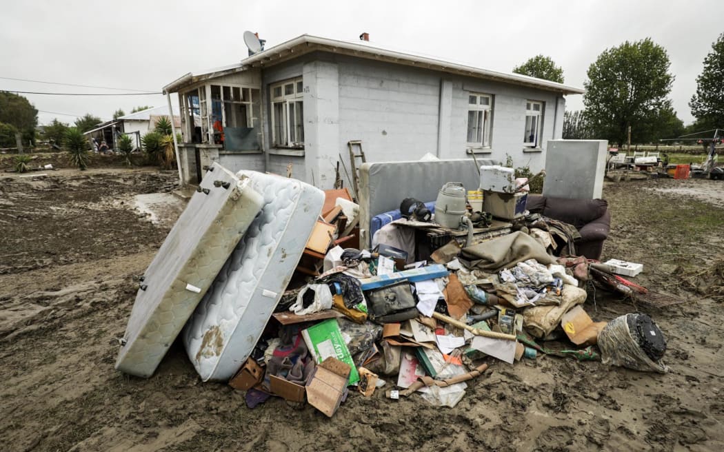 Debris piled up in front of a damaged house in Wairoa