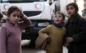 Syrian children meet an aid convoy in a rebel-held suburb on the outskirts of Damascus.