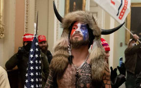 Supporters of US President Donald Trump, including Jake Angeli, a QAnon supporter known for his painted face and horned hat, protest in the US Capitol on January 6, 2021, in Washington, DC.