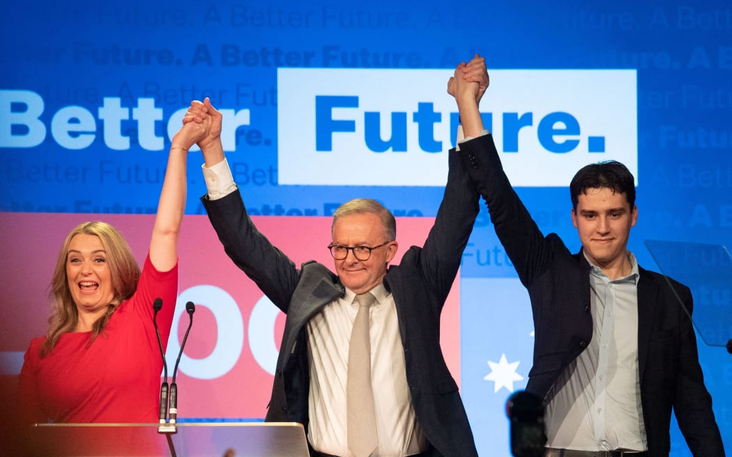 Australian opposition leader Anthony Albanese (C), accompanied by his partner Jodie Haydon and son Nathan Albanese, gesture as they arrive at a reception after winning the 2022 general election in Sydney on 21 May 2022.