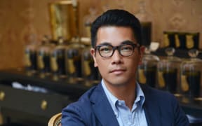 Christopher Yu sitting down and wearing glasses.