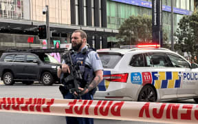Armed police stand behind a cordon in downtown Auckland following an active shooter situation on 20 July, 2023.
