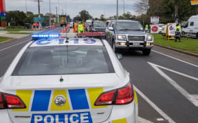 Police and military personnel check vehicles leaving the city at a COVID-19 check point setup at the southern boundary in Auckland on August 14, 2020.