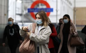 Commuters, some wearing face coverings to help prevent the spread of coronavirus, walk out of a Transport for London (TfL) underground train station.