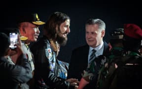New Zealand pilot Phillip Mehrtens (C), who was snatched by rebels in Indonesia's restive region of Papua in February last year, gestures as he walks with New Zealand Ambassador to Indonesia Kevin Burnett (C, right) after arriving from Central Papua by an air force plane at Halim Perdanakusuma air base in Jakarta on September 21, 2024. Phillip Mehrtens has been released from captivity by rebels in Indonesia's restive Papua region and is in good health despite the 19-month ordeal, Indonesian and New Zealand authorities said on September 21. (Photo by Yasuyoshi CHIBA / AFP)