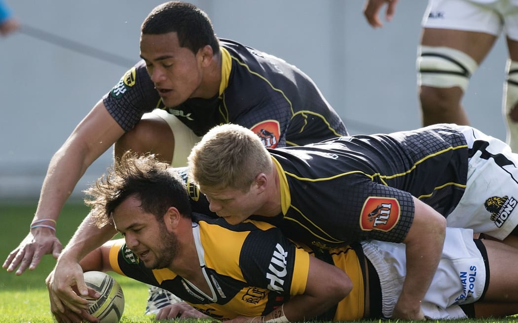 Taranaki's Jamison Gibson-Park scores a try as he is tackled by Lions' Vaea Fifita in 2014.