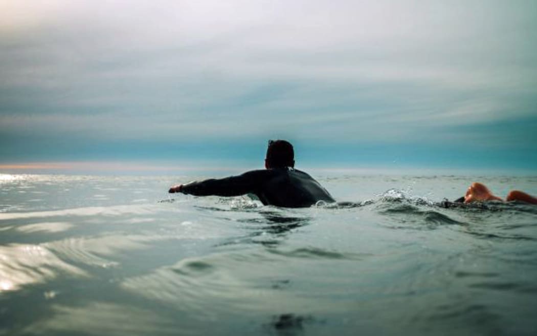 A surfer paddles out at Raglan.