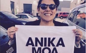 Anika Moa holding an Anika Moa-branded tea towel