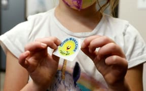 A 6-year-old child holds a sticker she received after getting the Pfizer-BioNTech Covid-19 vaccine at the Child Health Associates office in Novi, Michigan on 3 November 2021.