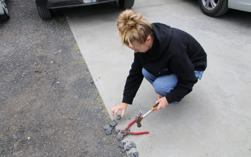 Local resident Pipi smashing salvaged tiles for her mosaic.