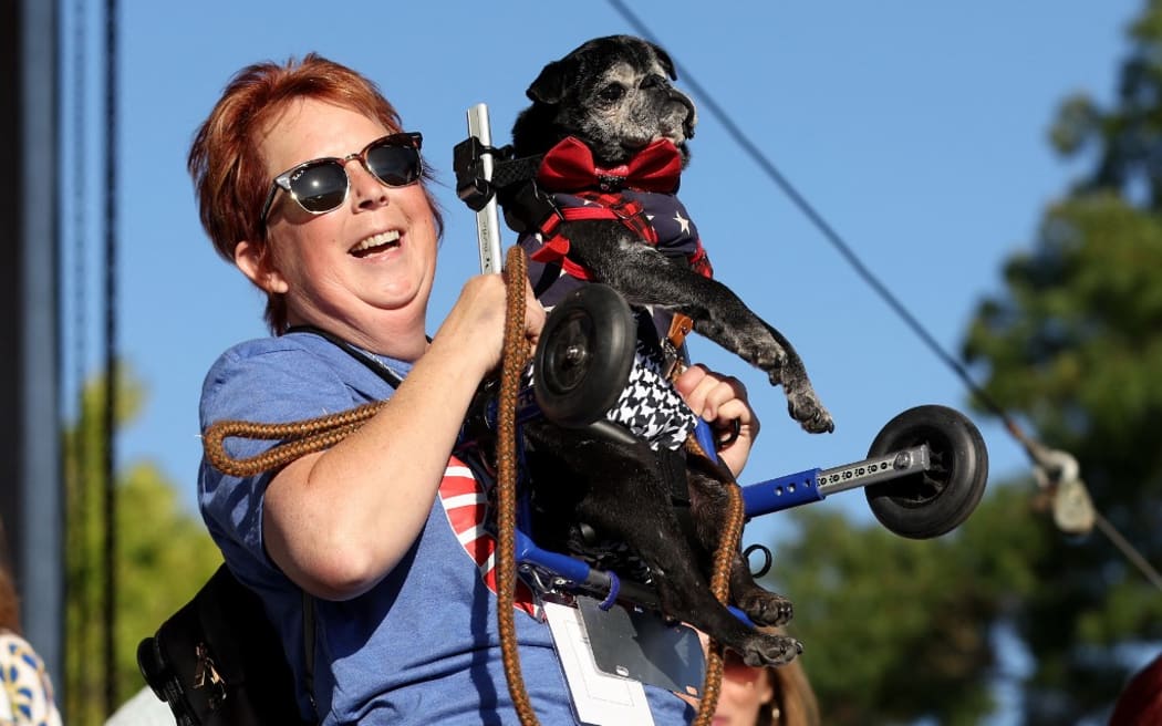 PETALUMA, CALIFORNIA - JUNE 21: Michelle Grady, of Rohnert Park, California, holds her dog Rome during the World's Ugliest Dog contest at the Marin-Sonoma County Fair on June 21, 2024 in Petaluma, California. A Pekingese dog named Wild Thang won the 34th annual World's Ugliest Dog contest and was awarded $5,000.   Justin Sullivan/Getty Images/AFP (Photo by JUSTIN SULLIVAN / GETTY IMAGES NORTH AMERICA / Getty Images via AFP)