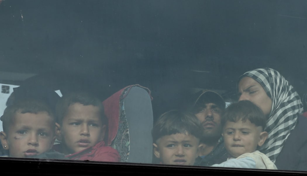 Refugees are seen on a bus during a police operation that began to evacuate the makeshift refugee camp at the Greek-Macedonian border.