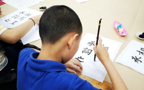 Young Chinese New Zealanders learning calligraphy.