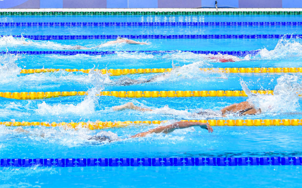 Swimmers racing in a pool.