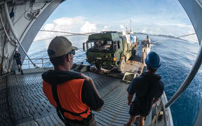 New Zealand Defence Force personnel unloading a truck off a Navy ship