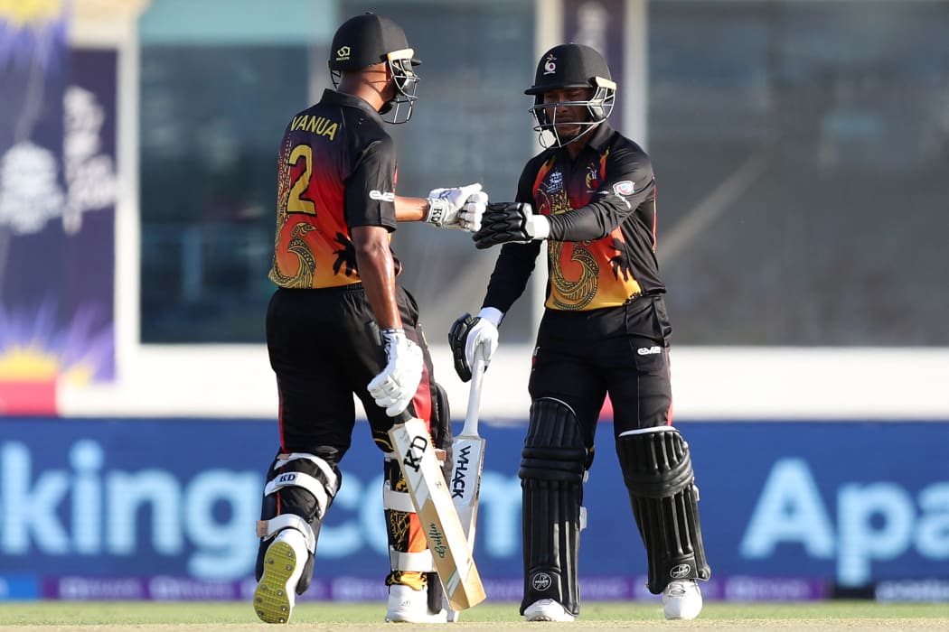 Papua New Guinea's Sese Bau (R) bumps his fist with teammate Norman Vanua during their T20 World Cup clash against Scotland.