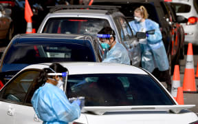 Medical personnel take details at a drive-through Covid-19 testing station in Melbourne on August 19, 2021, as Australia battles an outbreak of the Delta variant of coronavirus.