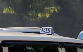 Taxi light sign or cab sign in white and blue color with white text on the car roof at the street blurred background, Myanmar.