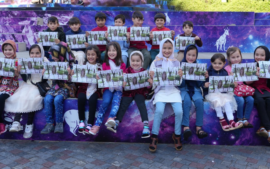 Afghan refugee children hold signs thanking Dr Ellen Nelson at a reunion and her team in Auckland July 2022