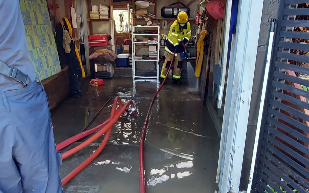 Emergency services pump out the Reweti whānau home's garage in 2021.