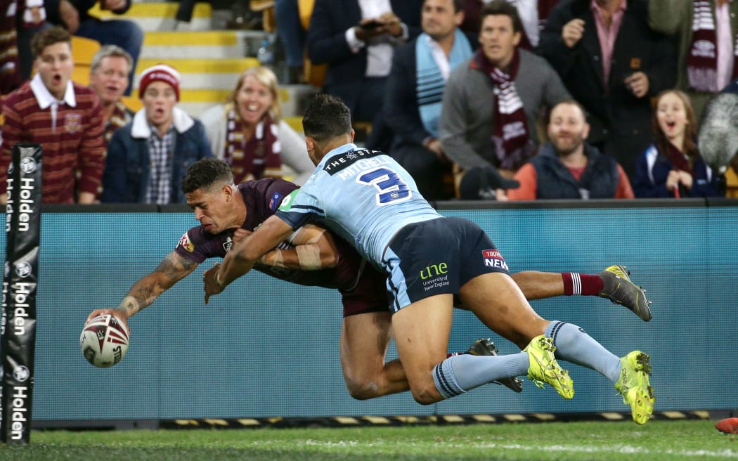 Dane Gagai of Queensland scores a try with Latrell Mitchell of New South Wales too late to stop him.