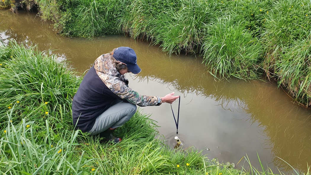 Christine tests water temperature and nitrate levels in the stream which runs through her property