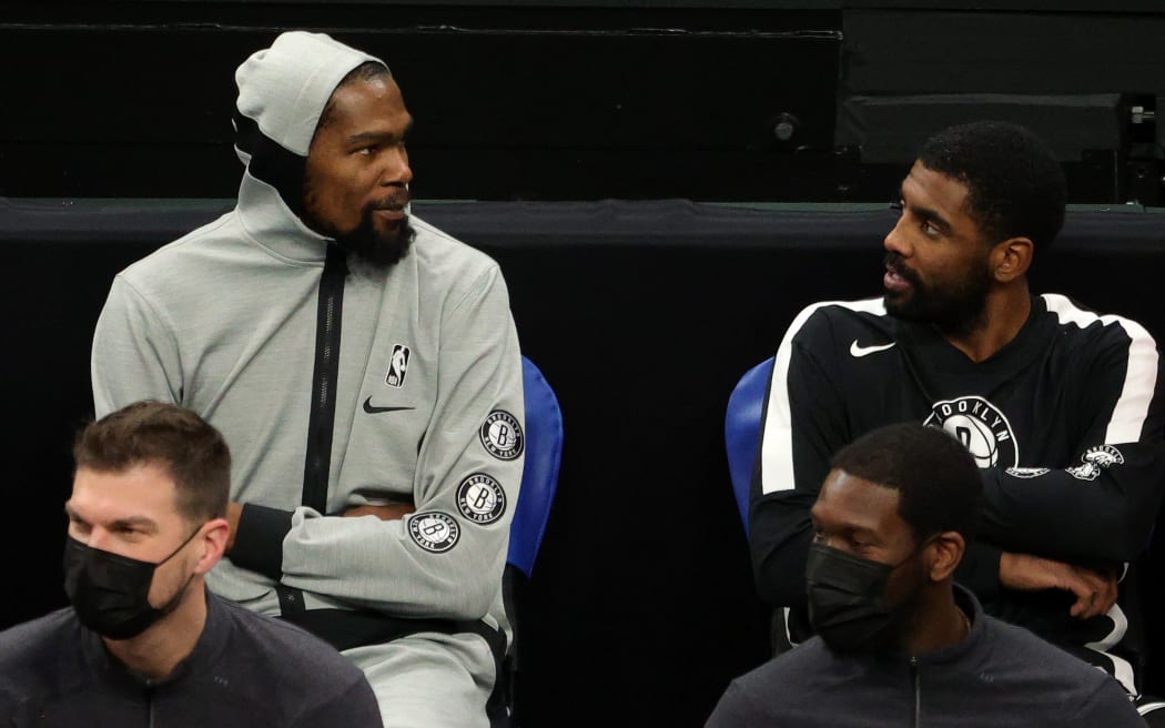 BOSTON, MASSACHUSETTS - DECEMBER 18: Kevin Durant #7 of the Brooklyn Nets and Kyrie Irving #11 talk together on the bench during the preseason game against the Boston Celtics at TD Garden on December 18, 2020 in Boston, Massachusetts.