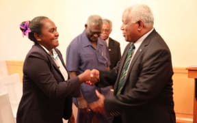 Solomon Islands' new Minister for Women, Youths, Children and Family Affairs,  Lanelle Tanangada, shakes hands with prime minister Rick Hou after her swearing in ceremony at Government House in Honiara.