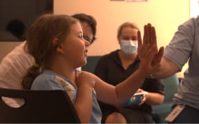 5-year-old Amiria Baldwin-Smith (Ngāti Waewae) celebrates after receiving her vaccine with a high-five from a Poutini Waiora nurse.