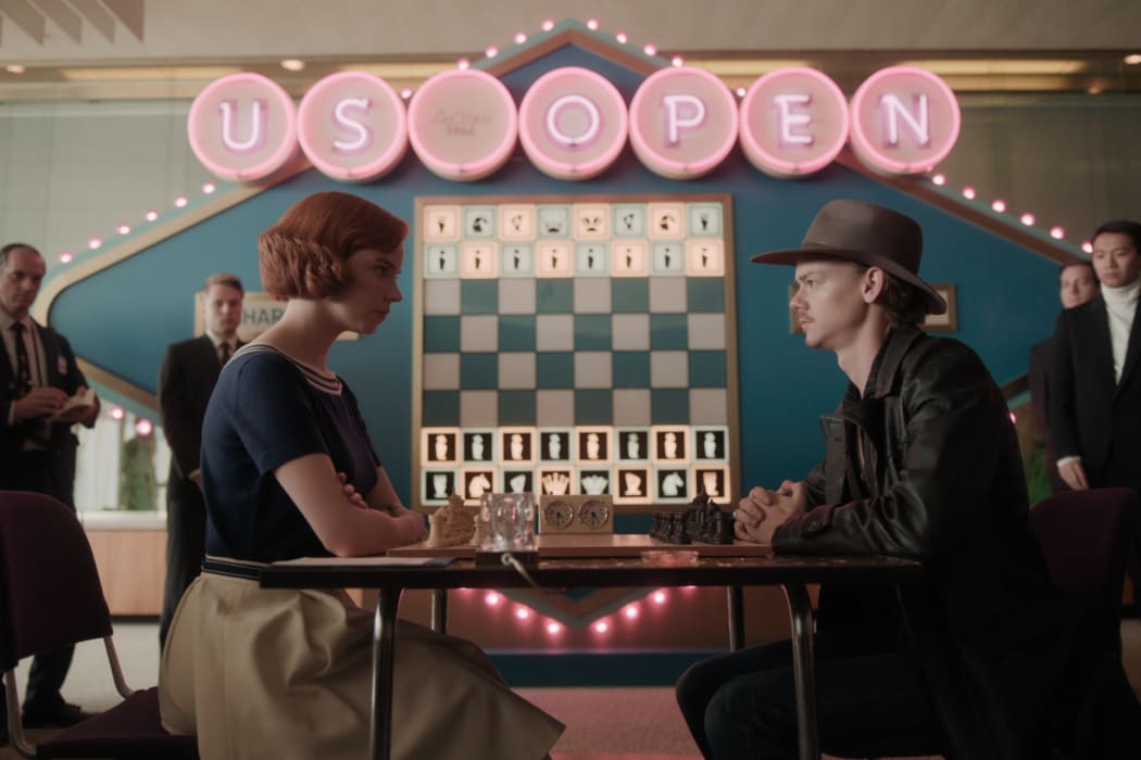 Anya Taylor-Joy as Beth Harmon faces off against Thomas Brodie-Sangster (Benny) in The Queen's Gambit.