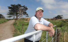 Opunake farmer Kerry Smith leaning on a fence.