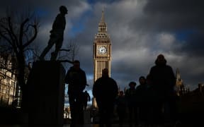 Pedestrians walk past the Elizabeth Tower, commonly known by the name of the clock's bell "Big Ben", at the Palace of Westminster, home to the Houses of Parliament, in central London, at sunset, on January 6, 2025. (Photo by HENRY NICHOLLS / AFP)